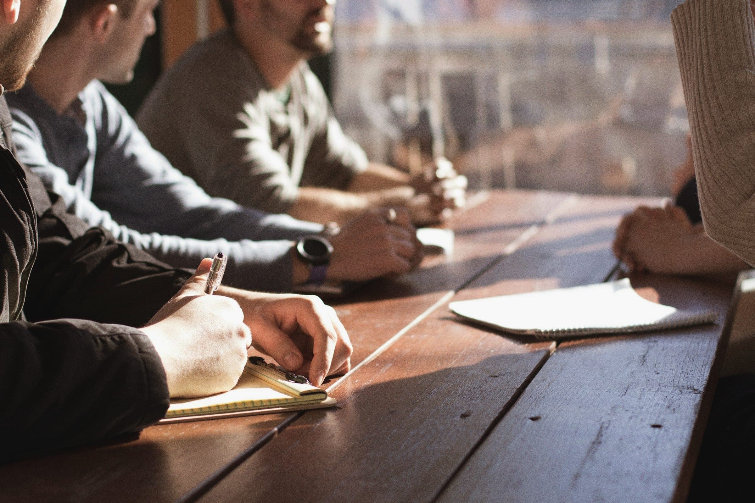 People around a table taking notes during a working session