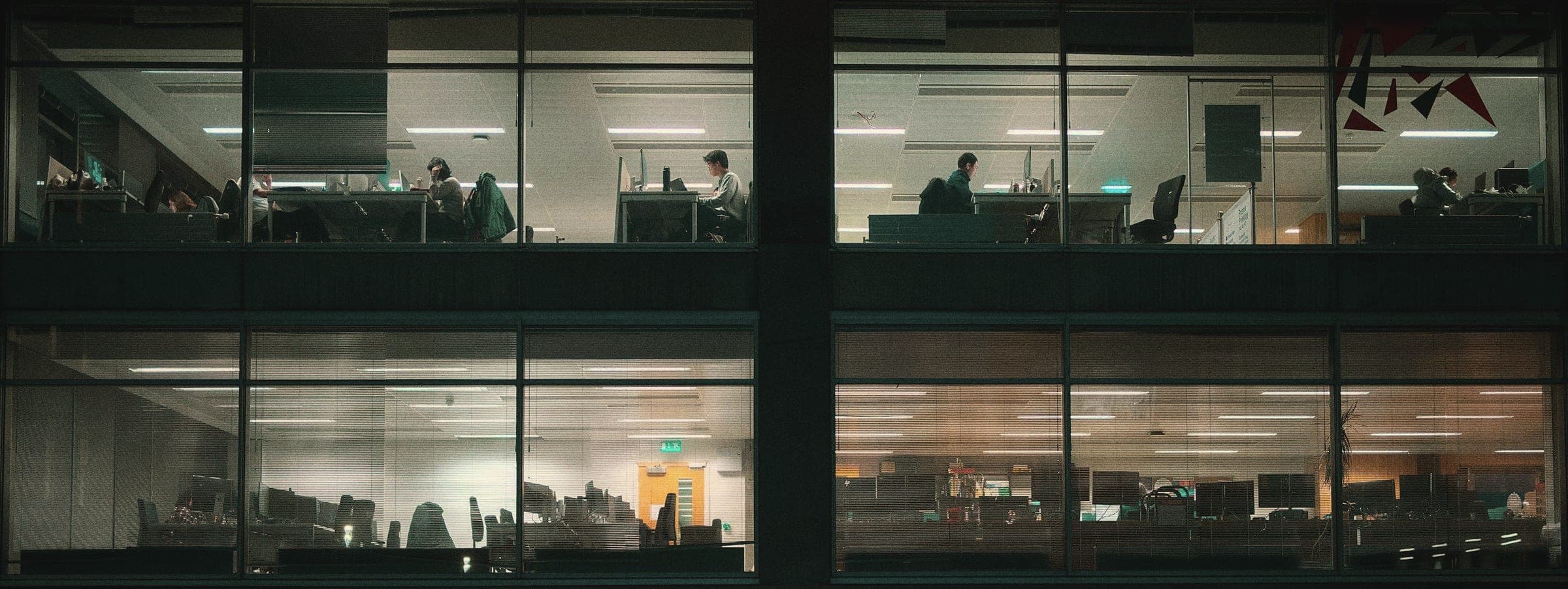 Office floors lit at night with people still working