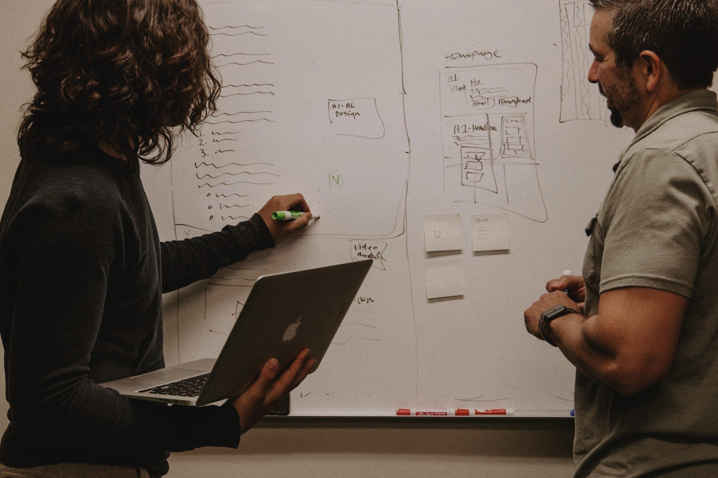 An engineer explaining a design on a whiteboard